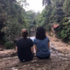 My friend and I sitting on the edge of a rock next to the cascade