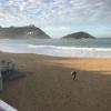 A surfer heading out to ride the waves off San Sebastian