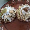 Sopes are a thicker, softer tortilla topped with beans, meat, lettuce, salsa, cheese, and cream