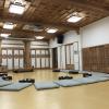 The head monk sits at the front of the tea room and everyone else sits criss-cross on their mats