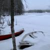 A picture of two docked rowboats with a frozen lake in the background.