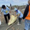 Teamwork makes the dream work! Students work together with their classmates to clean the beach