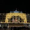 Large hotel lit up with lights to resemble curtains, featuring a large Christmas tree
