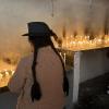 A Peruvian woman, dressed in traditional clothing, lighting a candle in the church