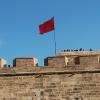 This is the Moroccan flag on a castle that overlooks the river and the ocean, called Oudaya