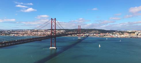 Trains, cars and buses cross this landmark bridge in Lisbon everyday. Does it remind of any bridge in the US?