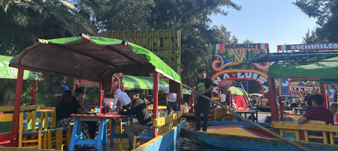 Bright and colorful trajineras (boats) float along the canals of Xochimilco, where locals and visitors enjoy music, food, and celebrations.