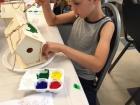 Aiden is painting a bird house; there's lots of artistic activities for kids to do here in France