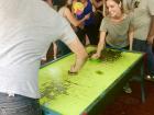 Deep into a game of air hockey. The room is loud with cheering for both players!