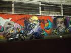 Motorcycles parked in front of a cool mural on a Medellín side street