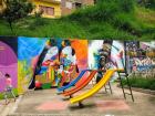 A playground situated alongside some colorful wall art 