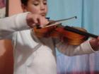 Showing off her violin skills in a home performance