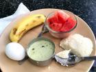A common breakfast - fruit, hard boiled egg, and idli with curry sauce