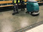 These workers are pushing around a machine that polishes the floor