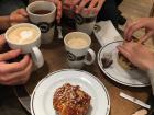 A traditional fika, featuring friends, coffee, and cinnamon rolls