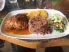 Caribbean chicken with a side of rice and beans, salad and crispy plantains