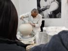A Korean artist shapes a vase using traditional pottery techniques