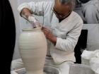 The artist uses precise hand movements to form the clay