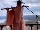 A musician in a Hanbok plays a traditional Korean flute