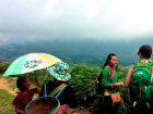 Bla speaks to Abby, while a Hmong woman and her granddaughter laugh in the background.