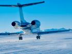 A small airplane landing on a blue-ice runway