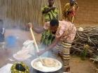 A woman making ugali in her backyard