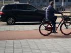 A pink bike lane separates cyclists from motorized traffic on the road