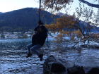 Swinging on a hanging tire in Queenstown over the lake
