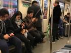 People on the metro reading and playing on their smartphones