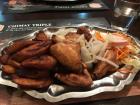 A plate of fried plantains, chicken wings and mixed salad