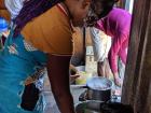 The chef uses a spoon to make nsima patties