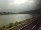 On a cloudy day, green hills descend to the banks of the Rhine River, which stretches down the western side of Germany 