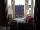 A dormer window looking over small town rooftops