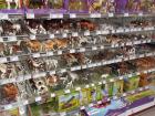 Shelves of animal miniatures, from horses to dragons, lining the aisle of a department store