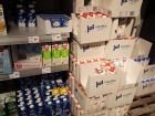 Boxes full of cartons of milk lining the shelves of a supermarket