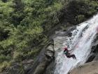 My friend rapelling down a waterfall in Baños