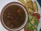 Beef stew with fried potato strips and a salad mix
