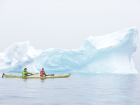 Explorers kayaking through the icebergs