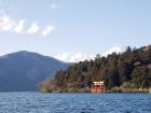 View of Hakone Temple's Heiwa-no-Torii from across Lake Ashi with Mt. Fuji snow-covered peak in the background