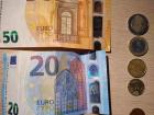 A 50 and 20 euro bill with assorted euro coins