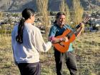 My friend Eduardo playing the guitar on a hill overlooking Esquel, while my friend Lucas holds a microphone