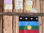 The Mapuche flag and signs reading "We defend our territory" in the central lodge of the Mapuche Melo community