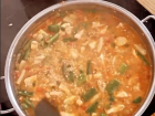 Stirring our chicken and veggies with saffron-spiced broth to make the rice golden!