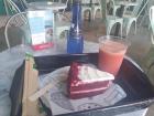 A slice of red velvet cake and juice