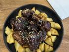 This is a picture of barbecue pork ribs and fried potatoes; it's very common to see dishes with pork or other meats and potatoes