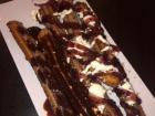 Churros are a popular dessert in Mexico; these are covered with chocolate and berry flavored sauce