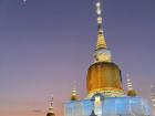 The famous Phra That Na Dun Pagoda lit up at night during a local festival