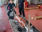 Crew members cook the Christmas Lechon