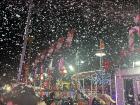 A snow-machine makes fake snow over market-goers