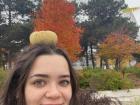 Me with a pumpkin on my head, taking a picture in front of the Biosphere and capturing the changes in the leaves